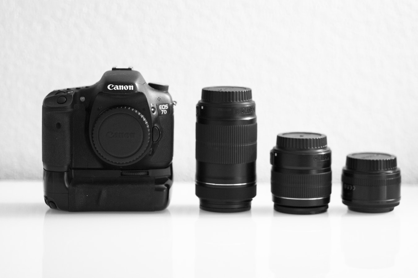 Canon EOS 7D DSLR camera with battery pack and three interchangeable lenses
