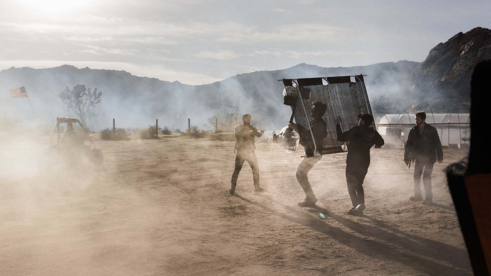 Dusty action film location with film crew and actors