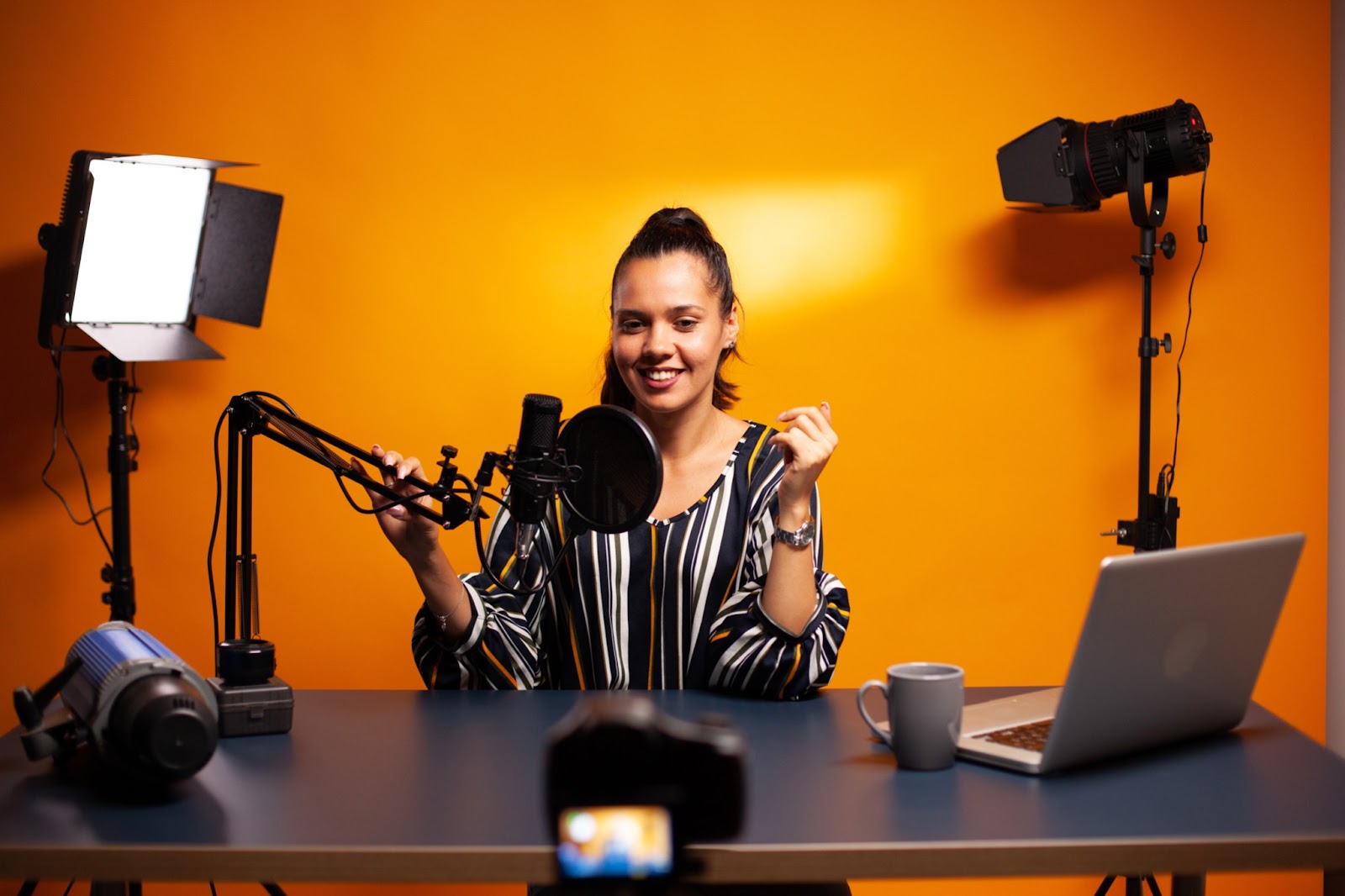 Content creator in home studio with microphone and lamps