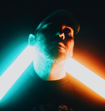 Man holds colorful LED wand lamps to light his face