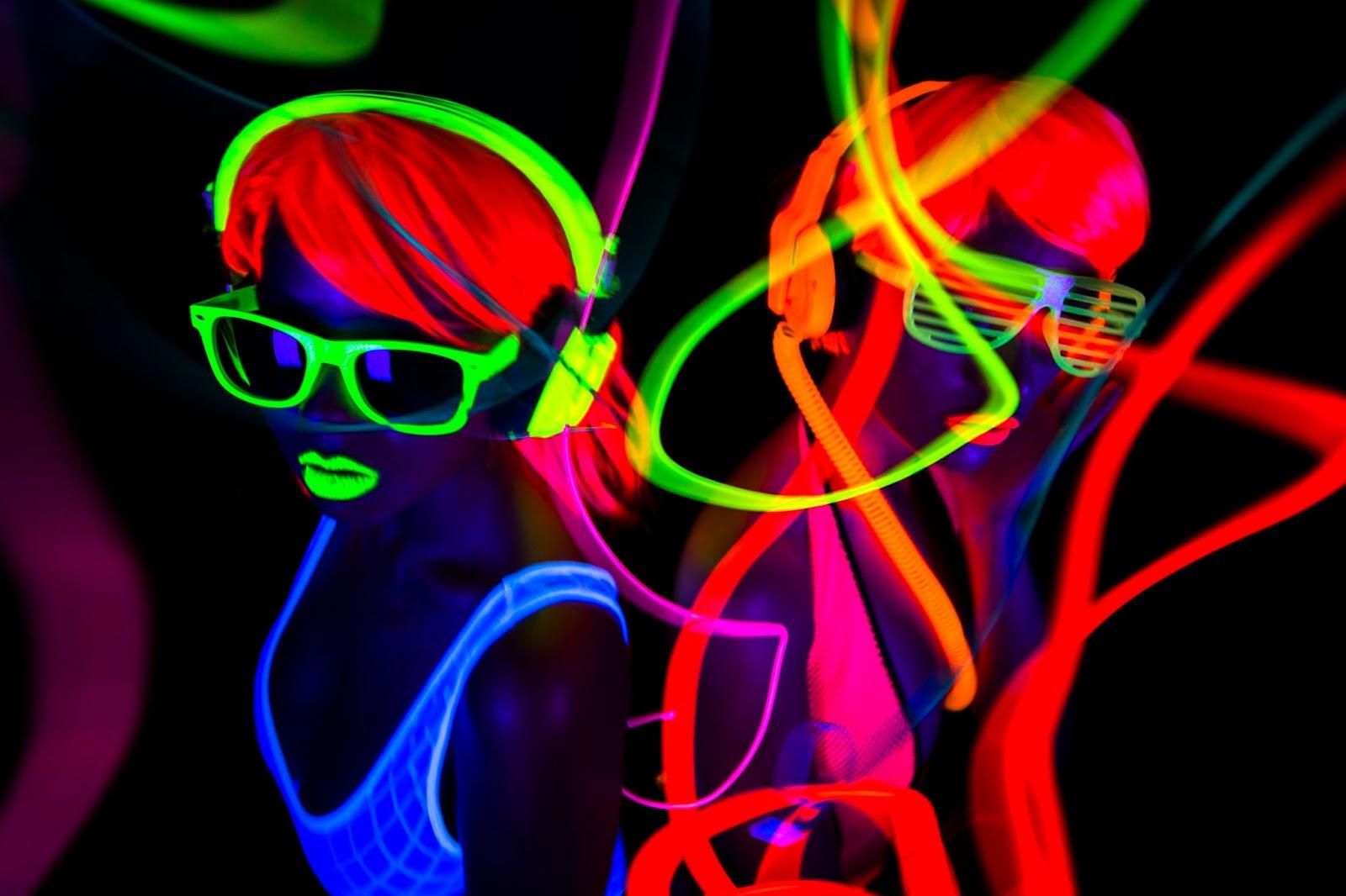 Model under black light with neon hair and headphones