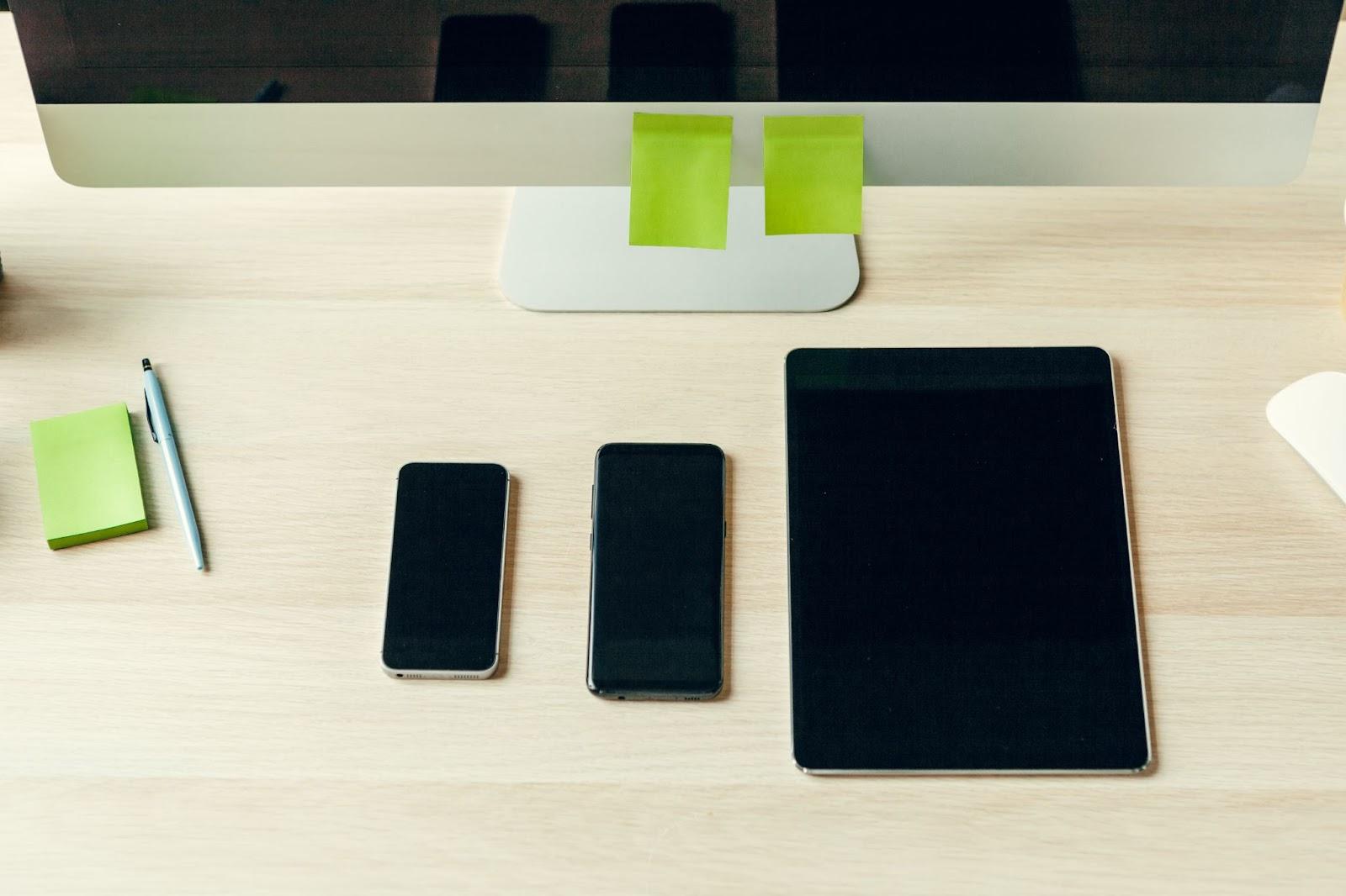Smartphones, tablet and computer monitor on a desk